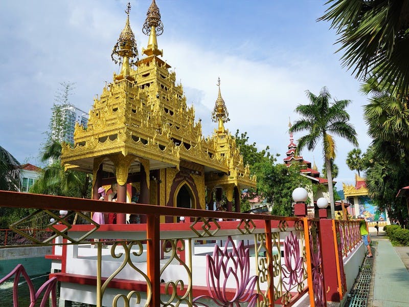 Prunkvoller, goldener Tempel in Borneo, im Vordergrund rotes Geländer