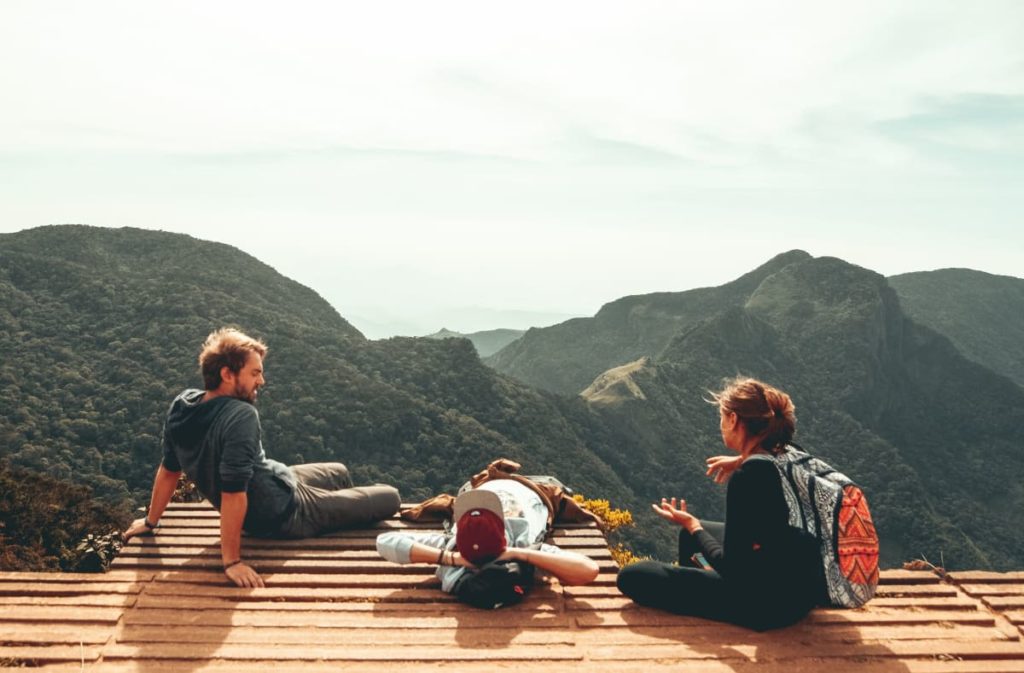 Drei Jungs sitzen auf einer Bank in einem Gebirge.