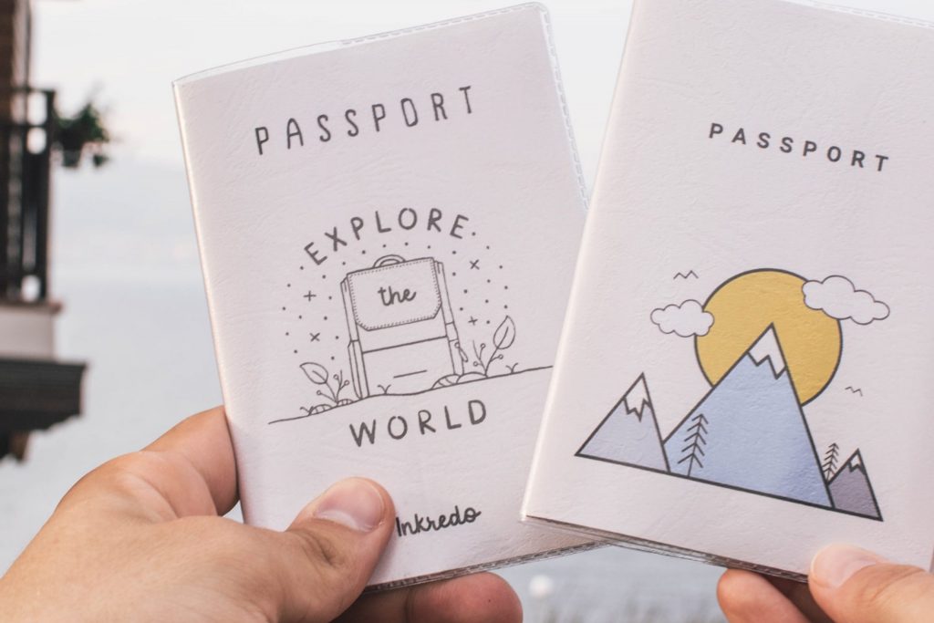 Two passports held up by a hand.