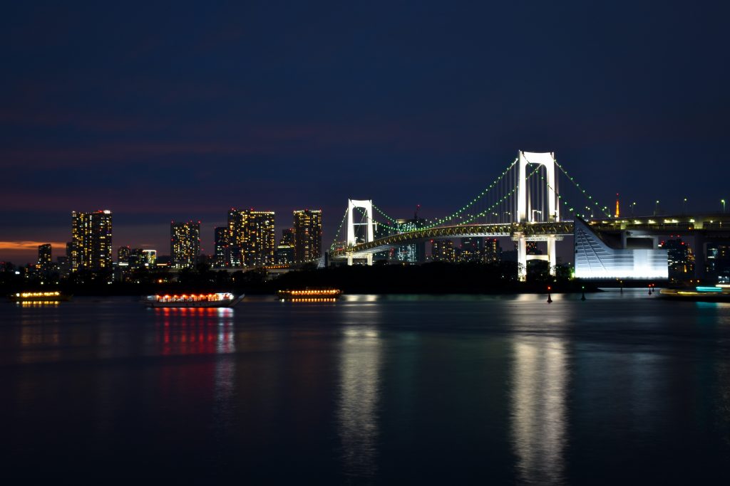 Odaiba in Japan during the evening time with the view of the bridge lit up.