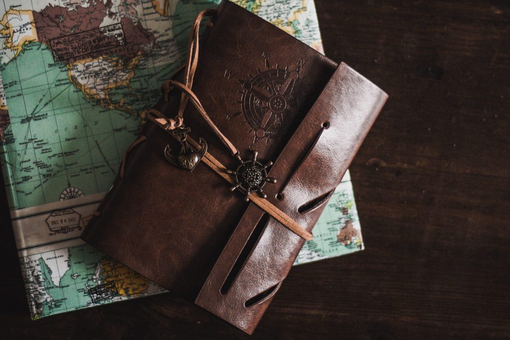 a brown travel diary lying on a world map. 