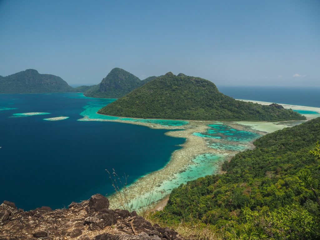 blue and green sea surrounded by stunning landscapes of green mountains in the beautiful photographer destination, Borneo