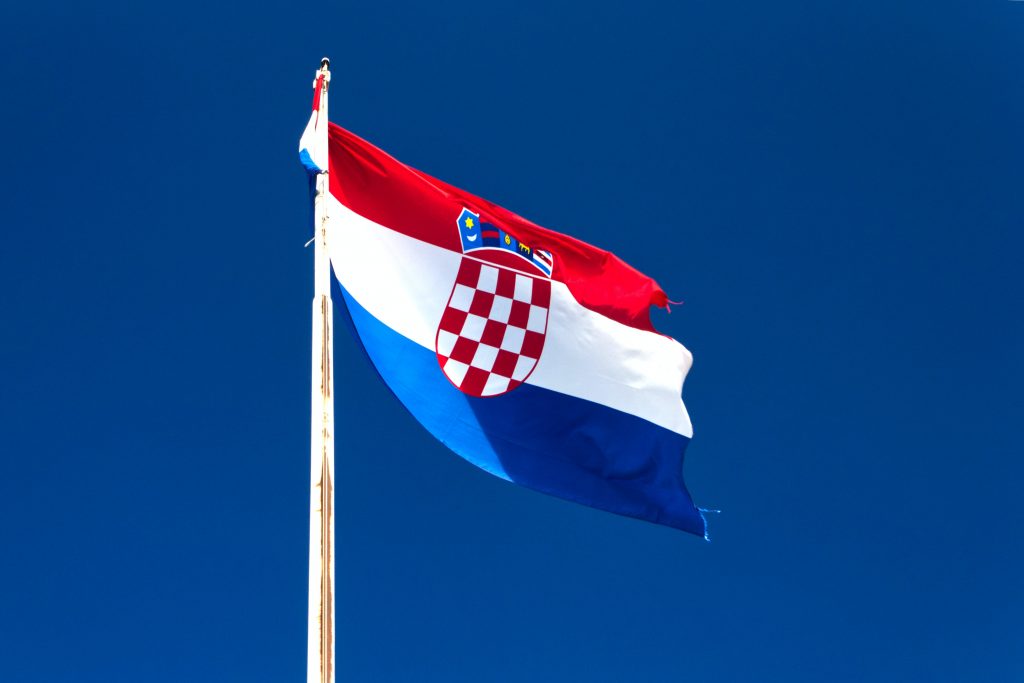 The Croatian flag with blue sky in the background.
