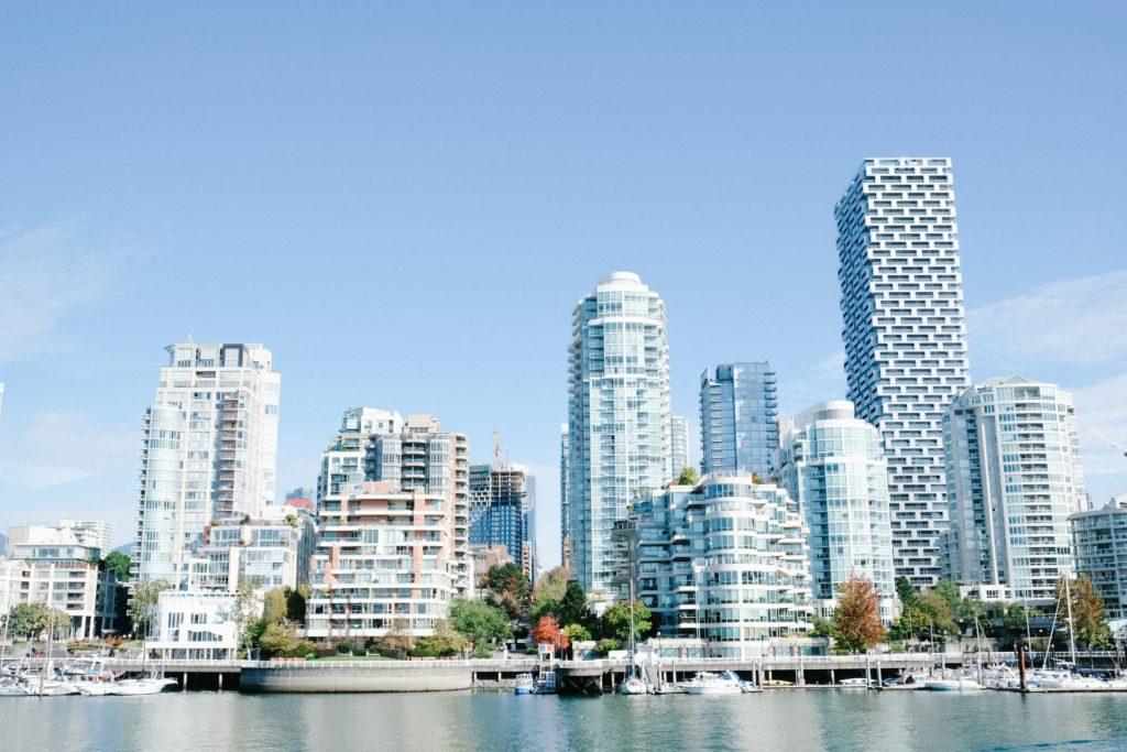 white and black high-rise buildings against the body of water at Granville Island, among the most famous tourist spots of Vancouver