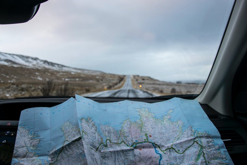 how to be the perfect trip leader - a road map in the window of a car with a road ahead 