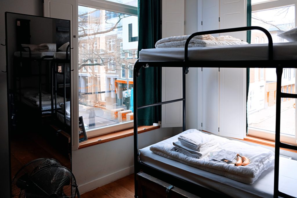 a picture of bunk beds in a hostel with bedding, hostels are the best accomodation type when backpacking asia 