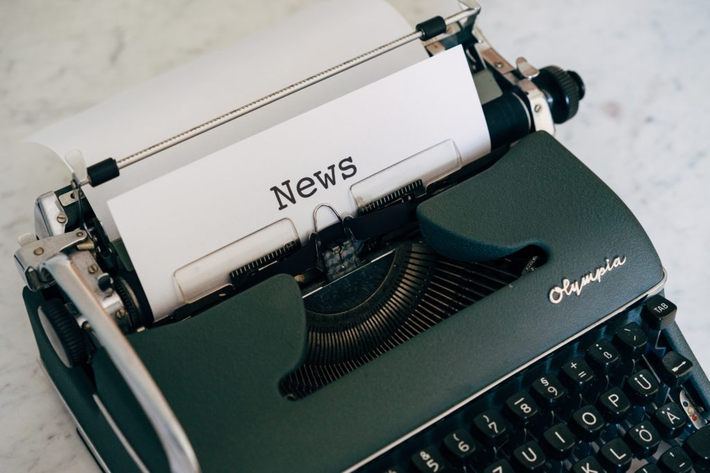 Eine alte Schreibmaschine mit einem Blatt Papier, auf dem News steht.