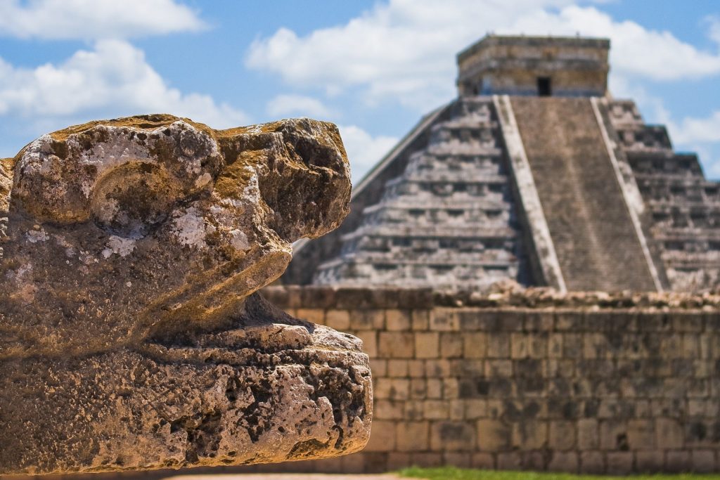 Pyramide und Steinfigur in Mexiko.