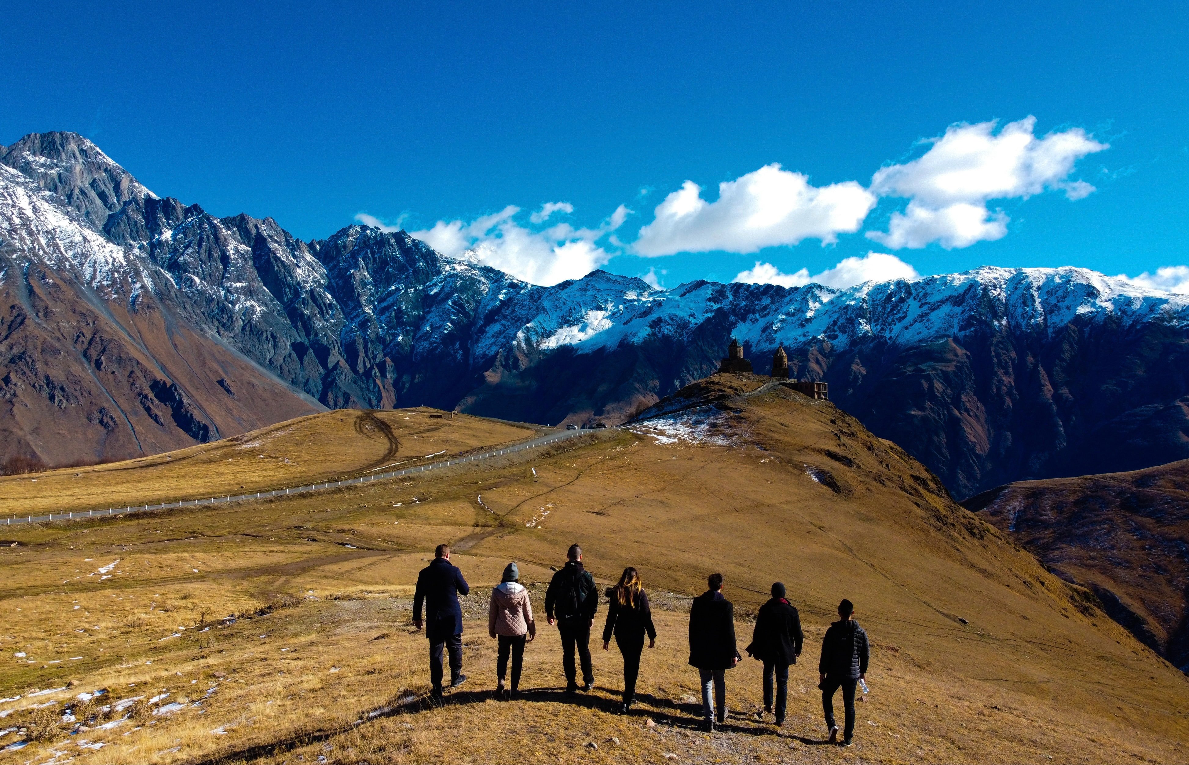 Reisegruppe vor einem Bergpanaorama. Gruppenreisen sparen eine Menge Geld und sind so sehr gut für euer Studierenden Budget
