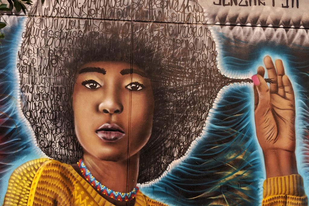 Mural art of a woman who is playing with her hair 