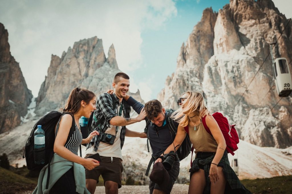 A group of travel buddies are laughing together on their trip, where they were traveling alone as a woman