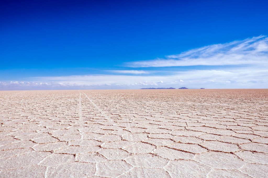 Endless white salt flats in Bolivia against a blue sky
