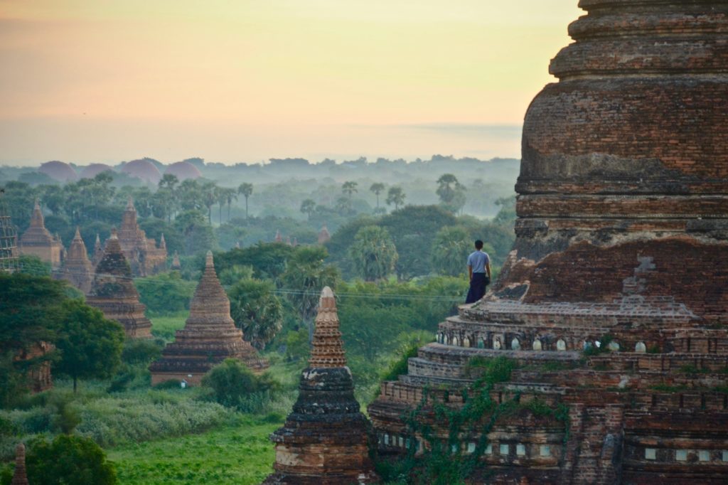A man is standing on an old bagan enjoying the view over myanmar the best places to travel in 2020