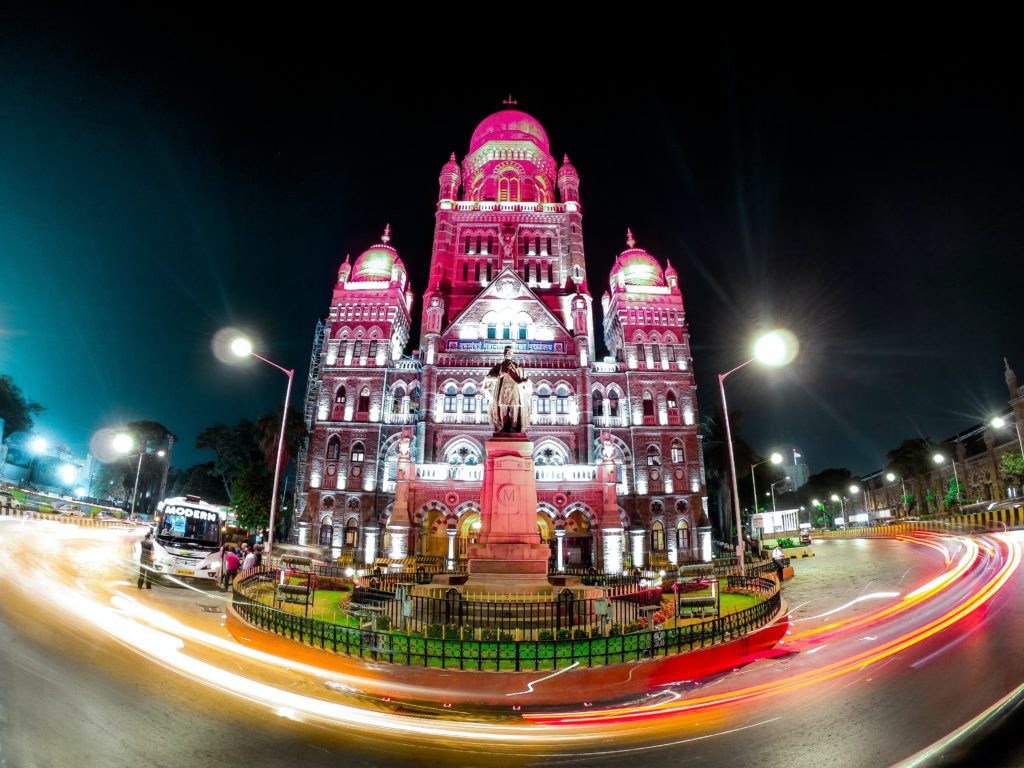 A colourful building surrounded by a street in the middle of mumbai as one of the best places to travel in 2020