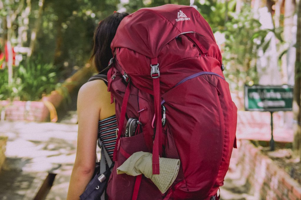 Packing one bag can be difficult so make sure you know how to. A woman with a big red bag. 