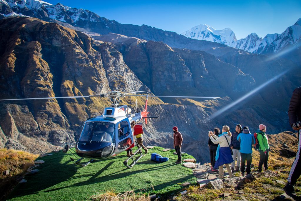 Annapurna Base Camp in Nepal with a helicopter and people.