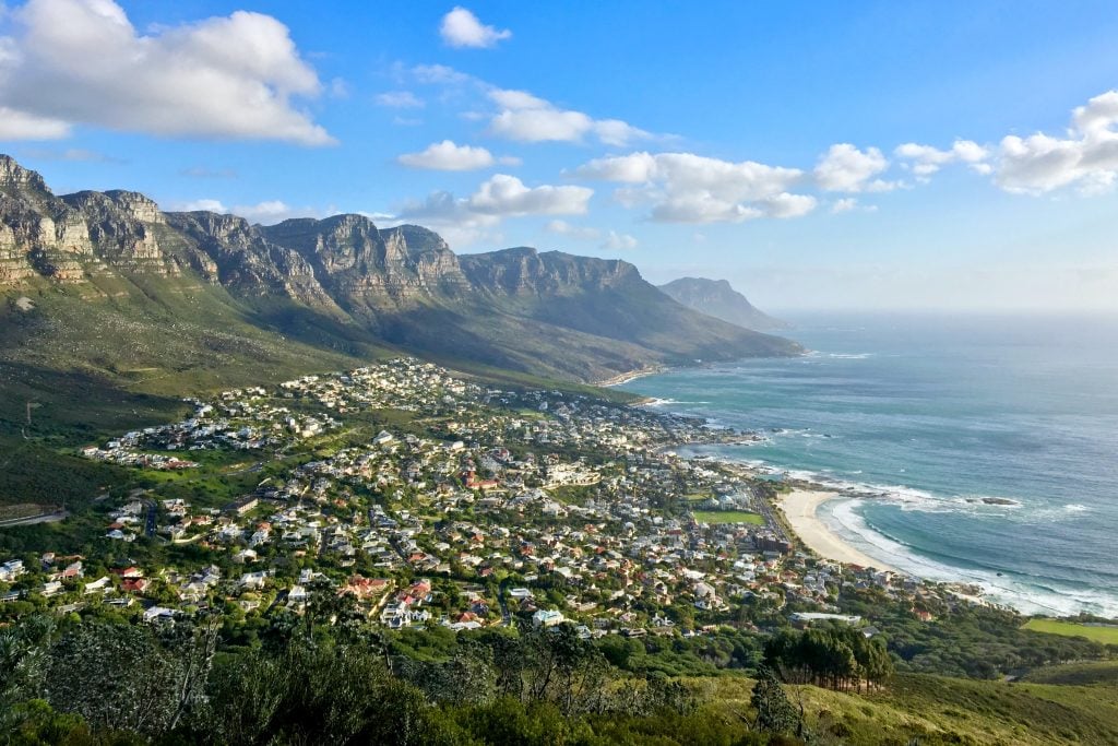 a view of Cape Town with the mountains and sea in  the day time with a clear blue sky. 