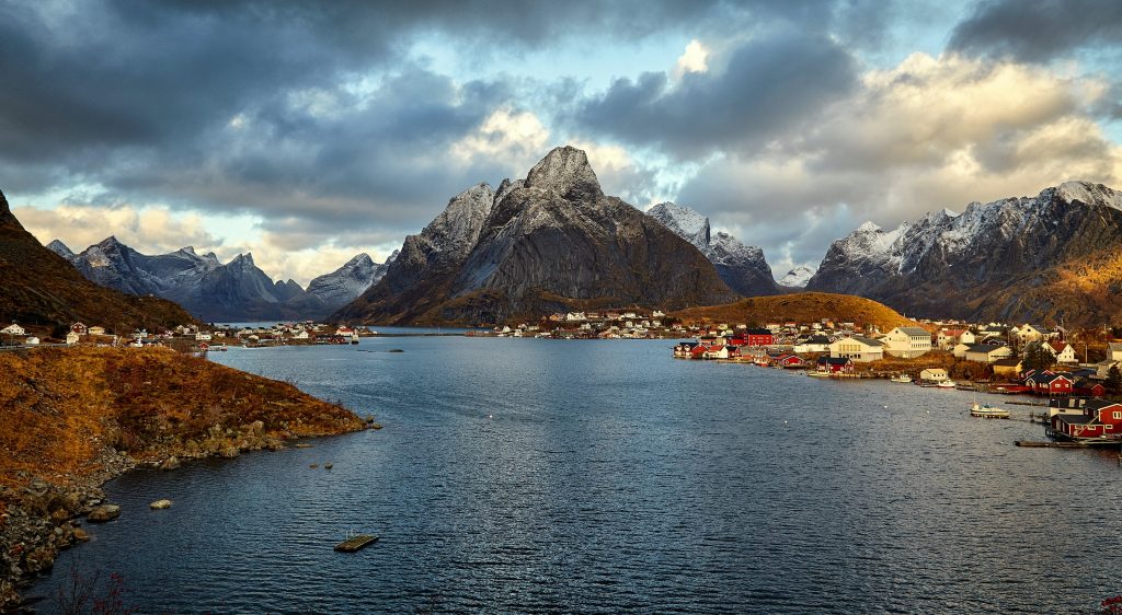 a view of lofted islands with mountains and dark grey clouds.