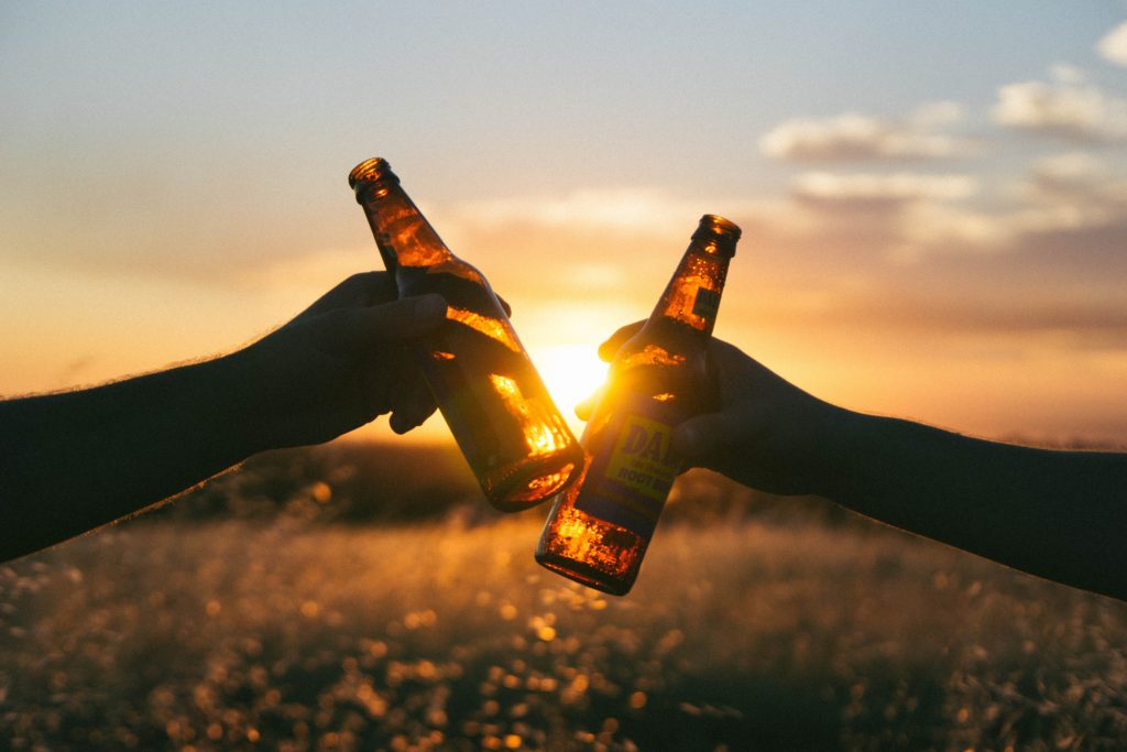Brauerei Tour: zwei Hände prosten sich mit Bier zu
