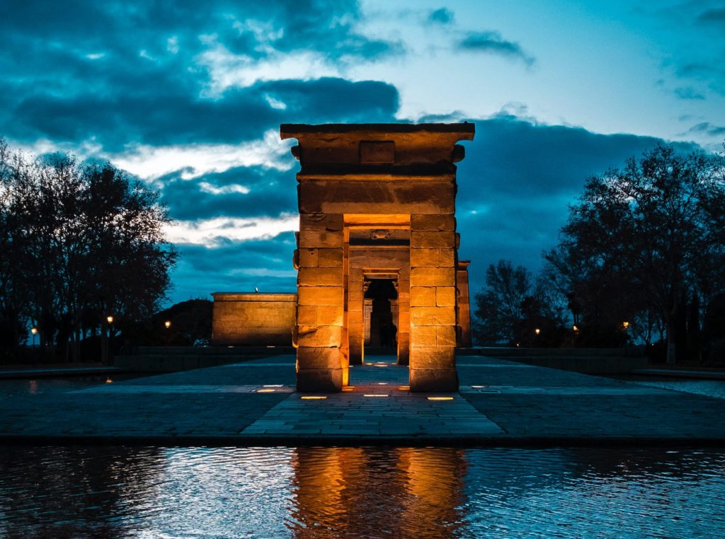 Plan your 2021 travel to Spain, Temple of Debod where there is a rock building standing still near the water.