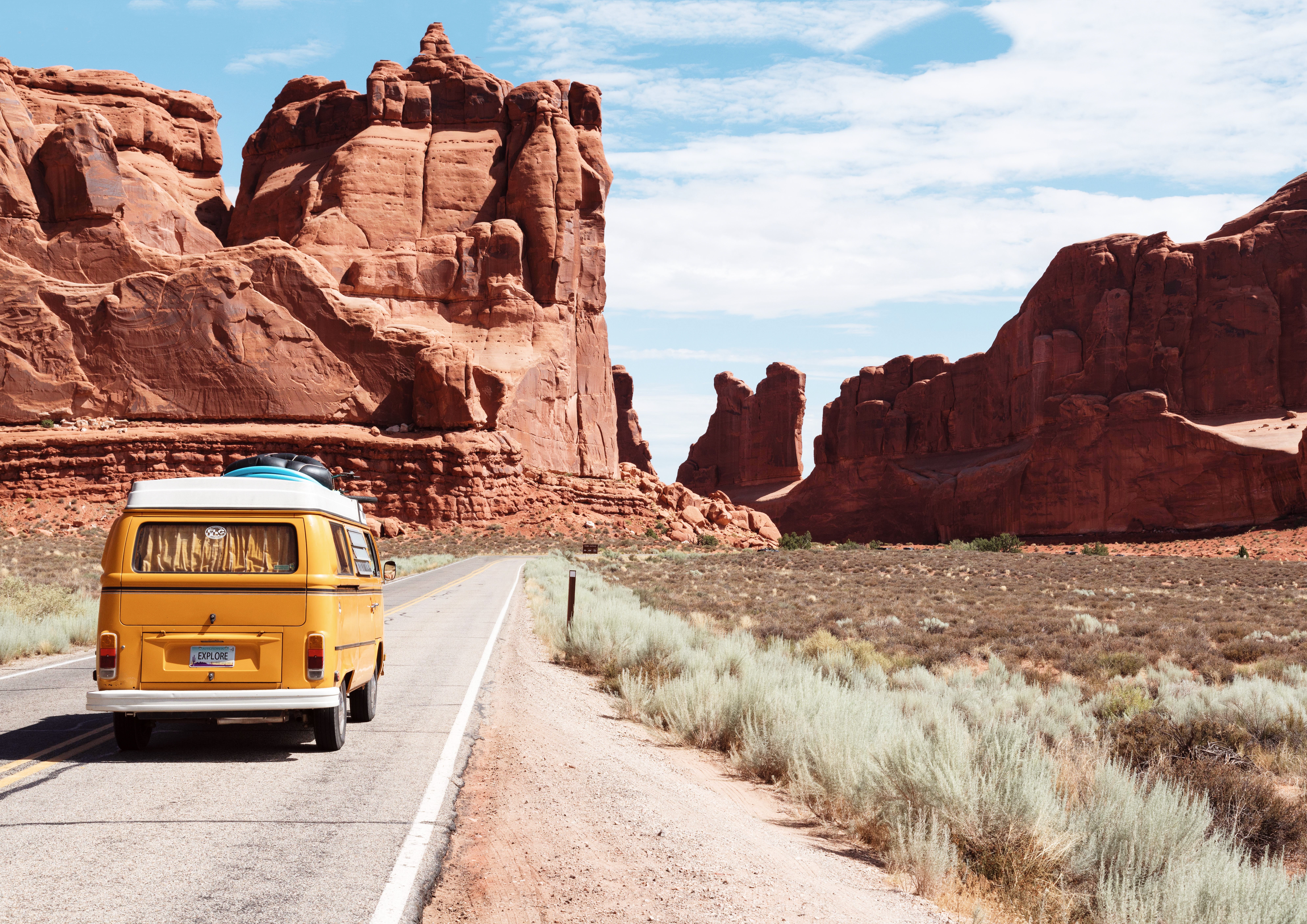 A yellow roadtrip van in a dry rocky landscape