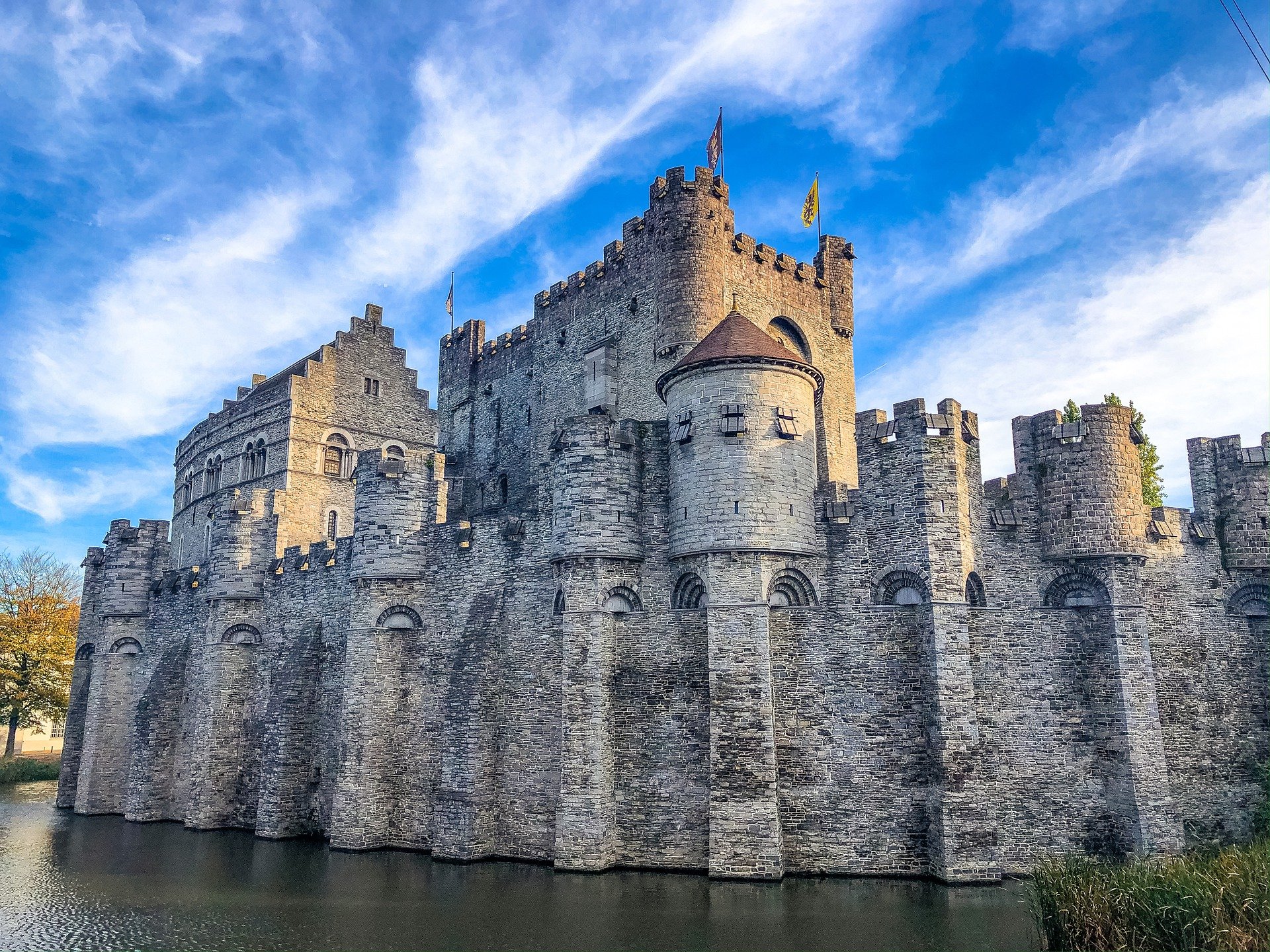 A grey medieval castle made from stone by the water in Belgium
