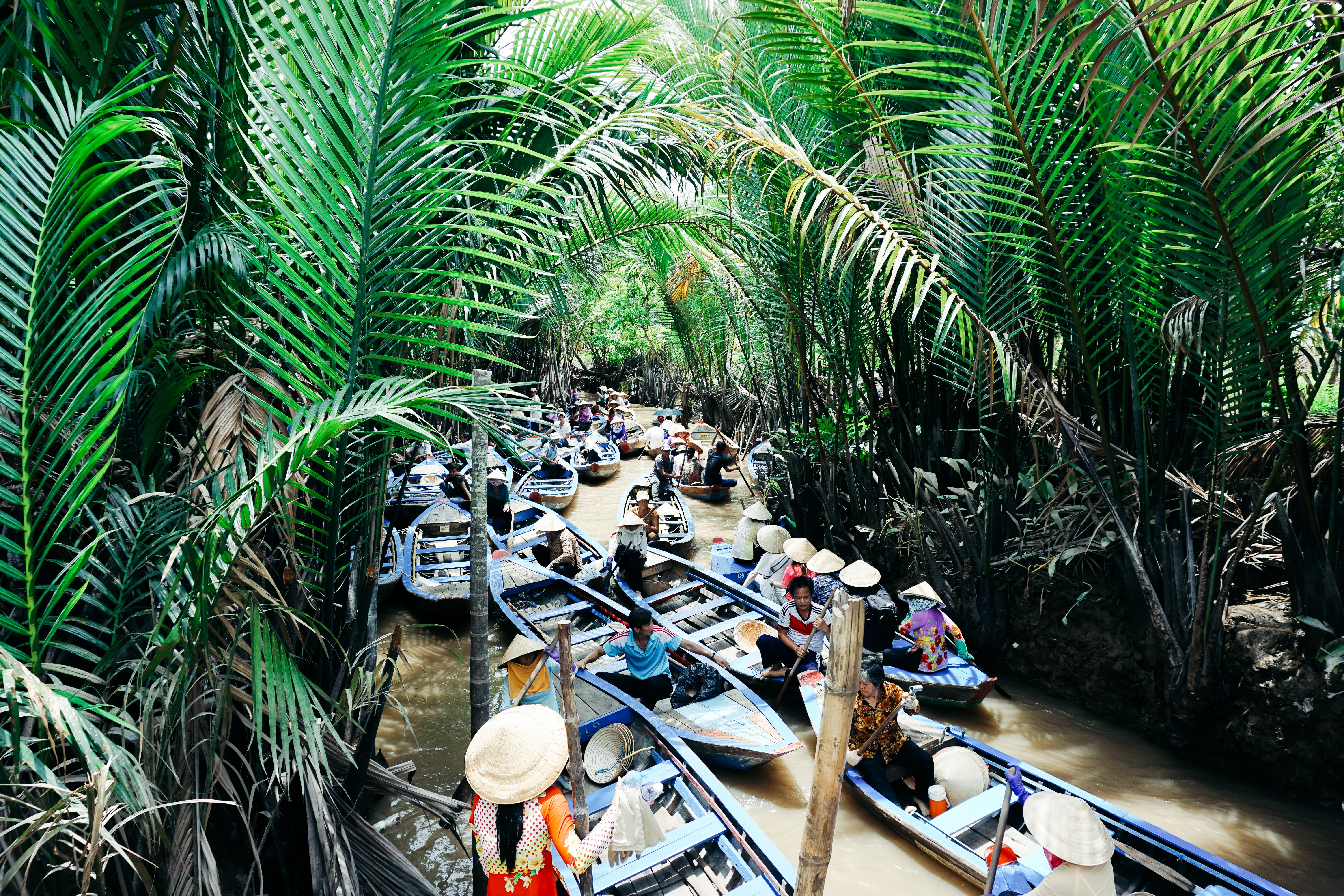 Ein kleiner Fluss mit vielen kleinen Holzbooten mitten im vietnamesischen Dschungel.