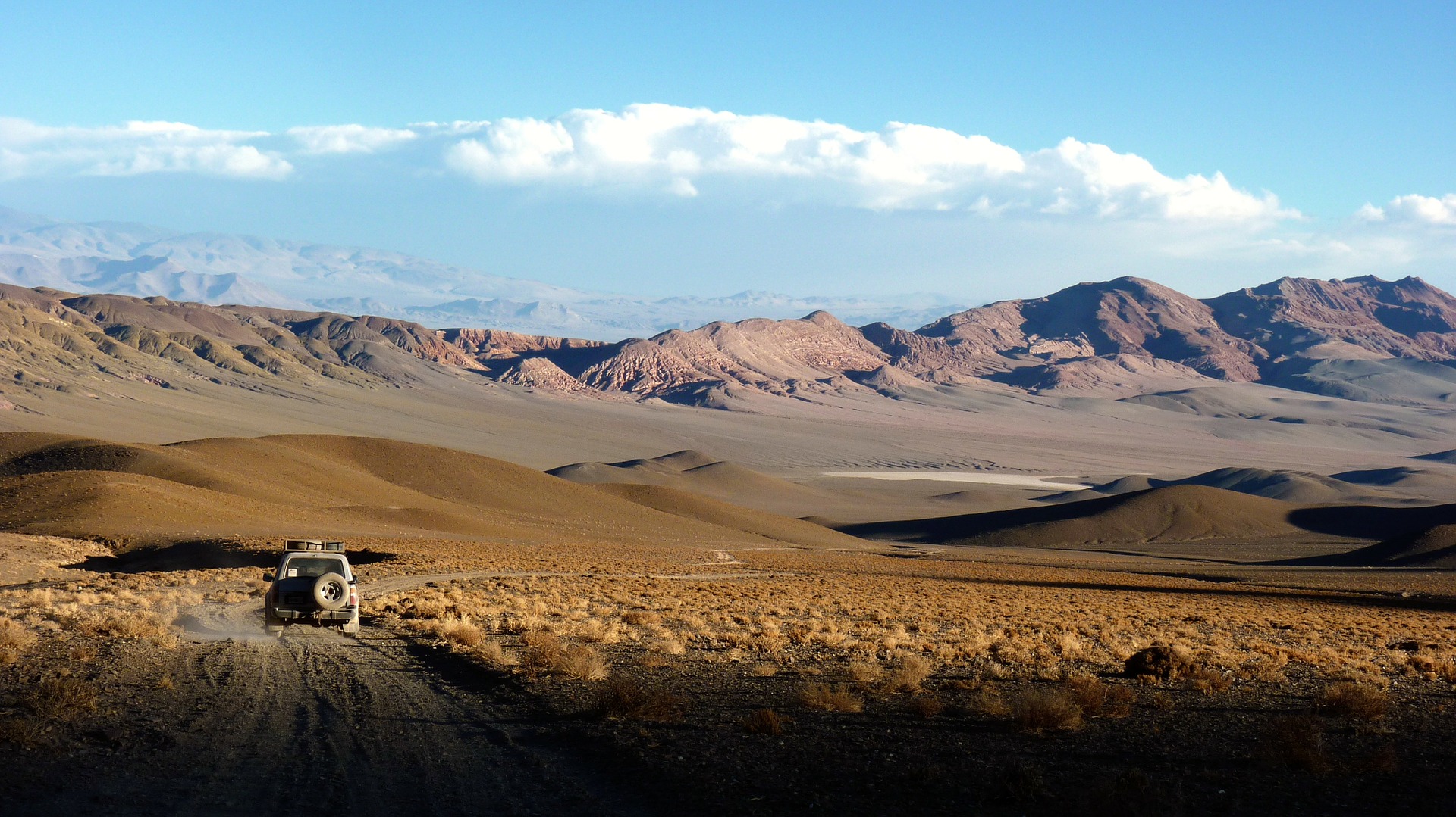Jeep driving in dry desert-like landscape
