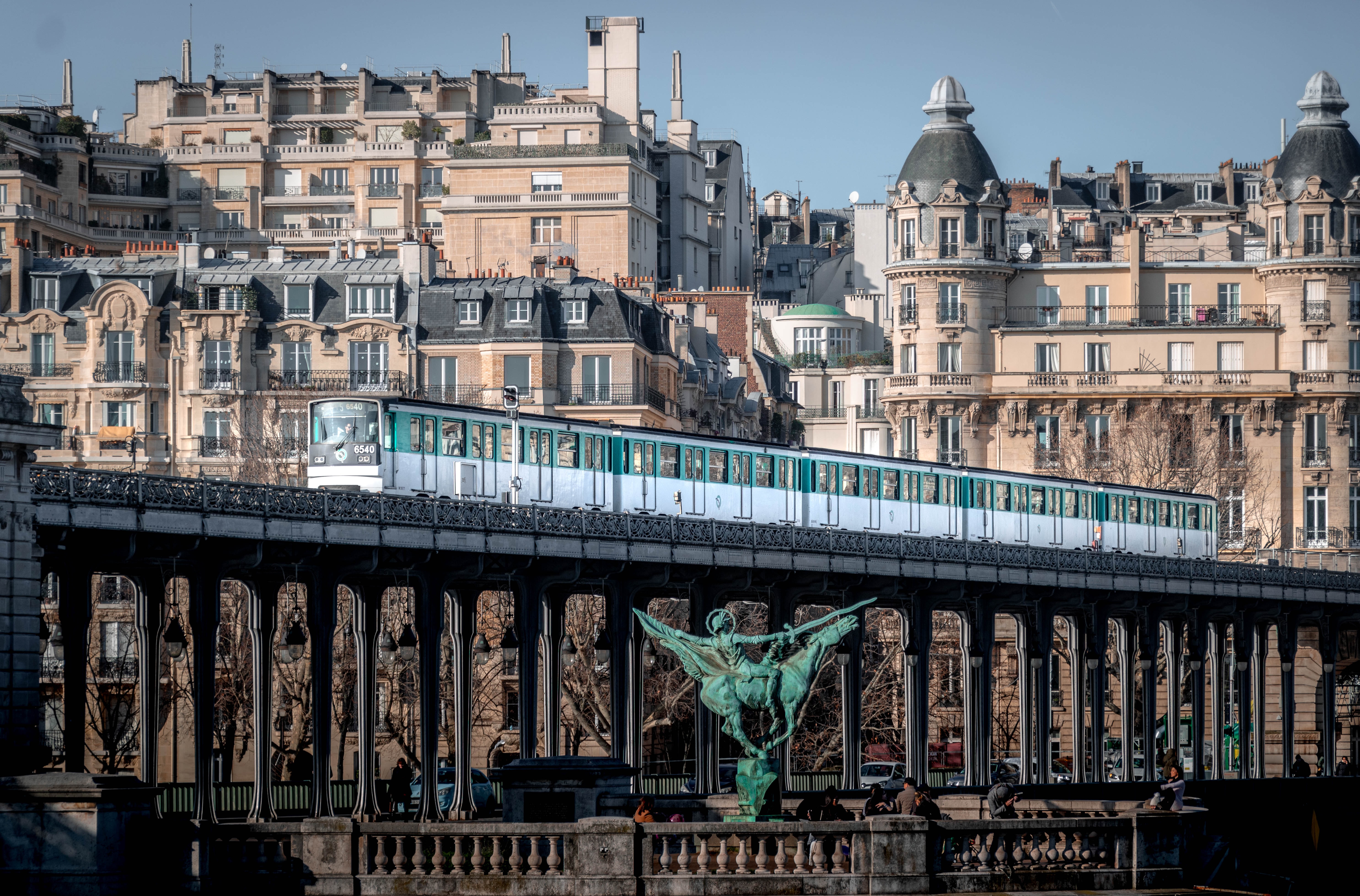 Metro on a bridge with Parisian buildings in the background