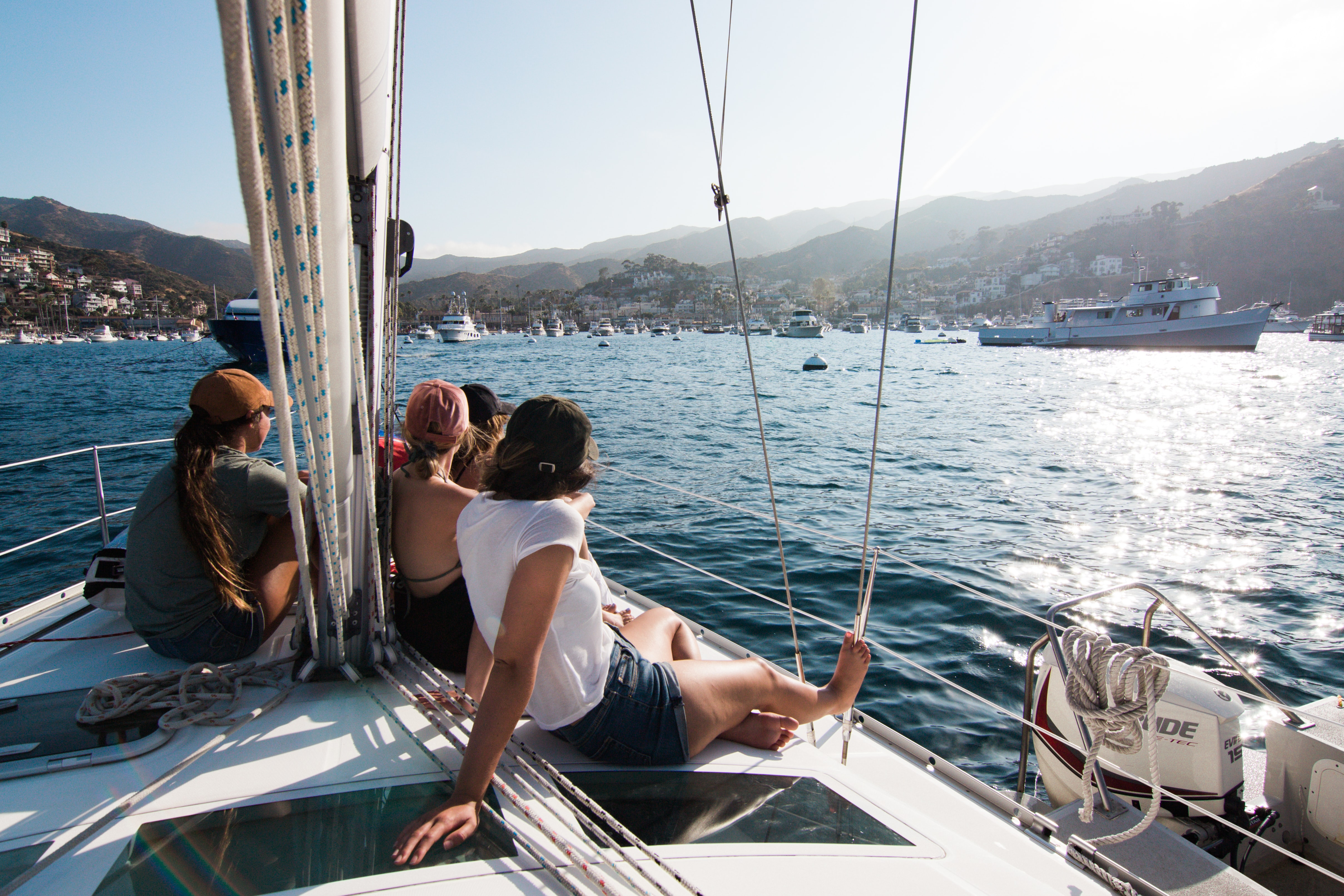 People relaxing on a sailboat in a mountainous scenery