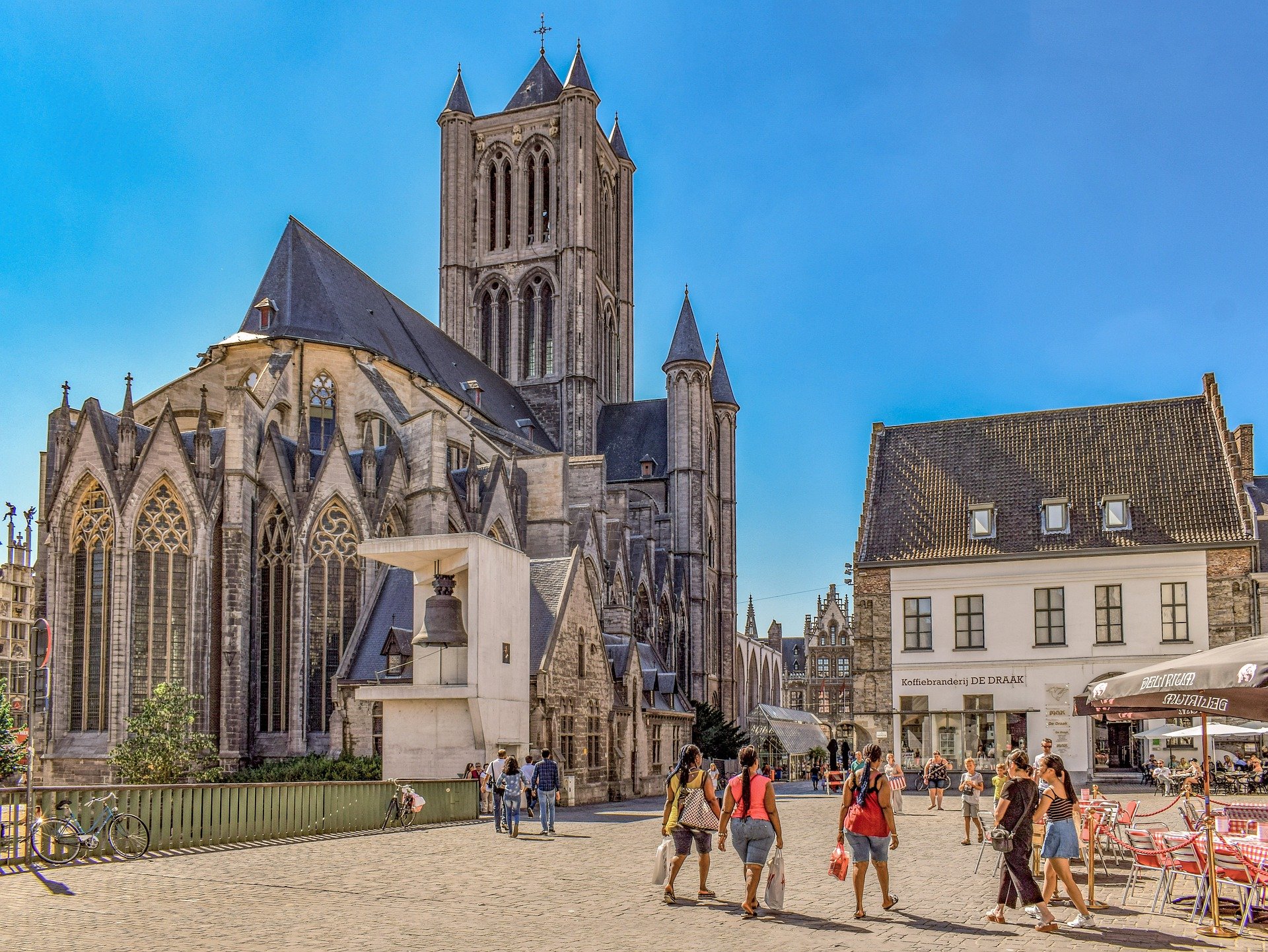 A medieval city center with church and old buildings and people in Belgium