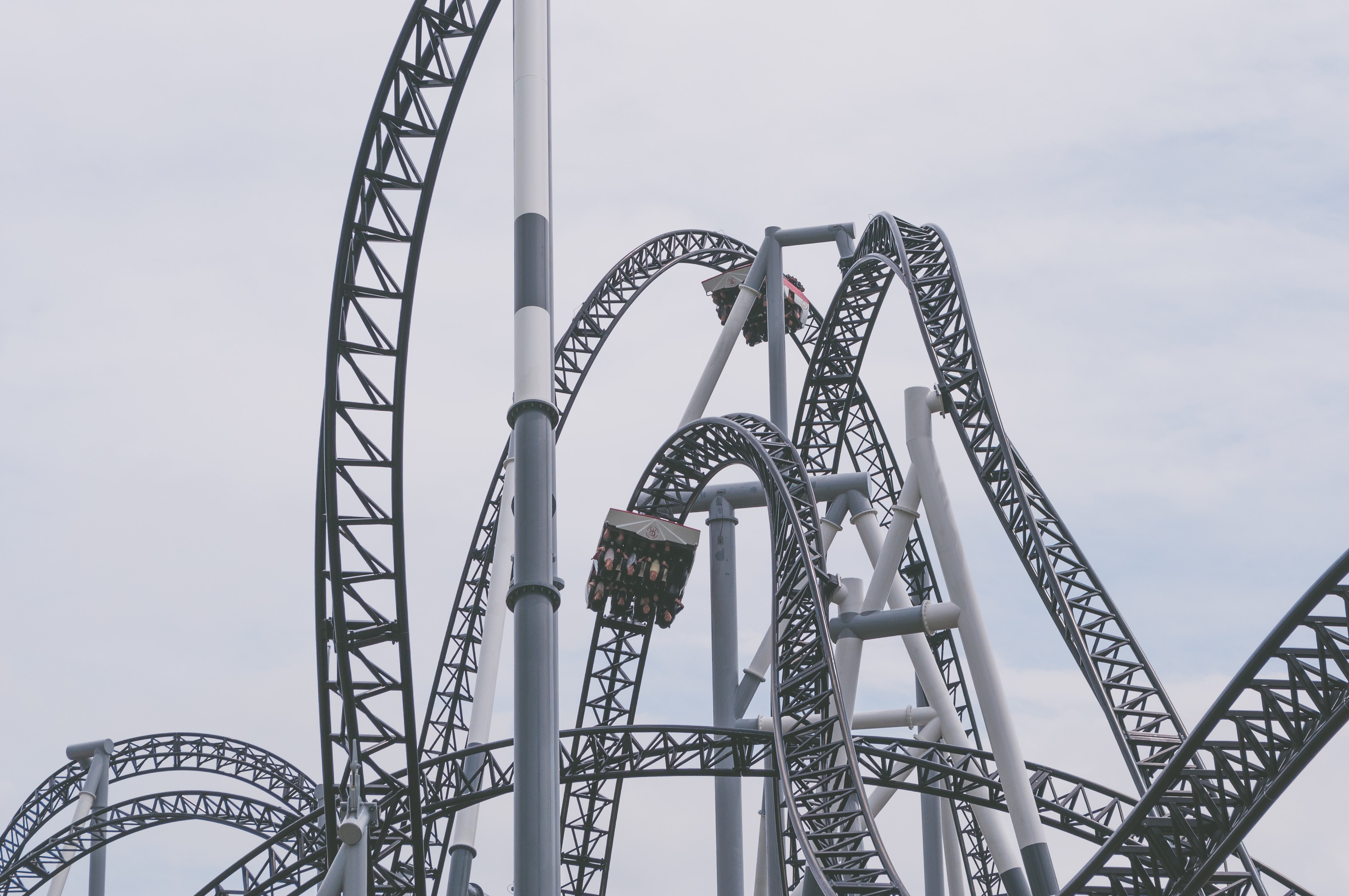 Winding steel roller coaster against a light gray sky.