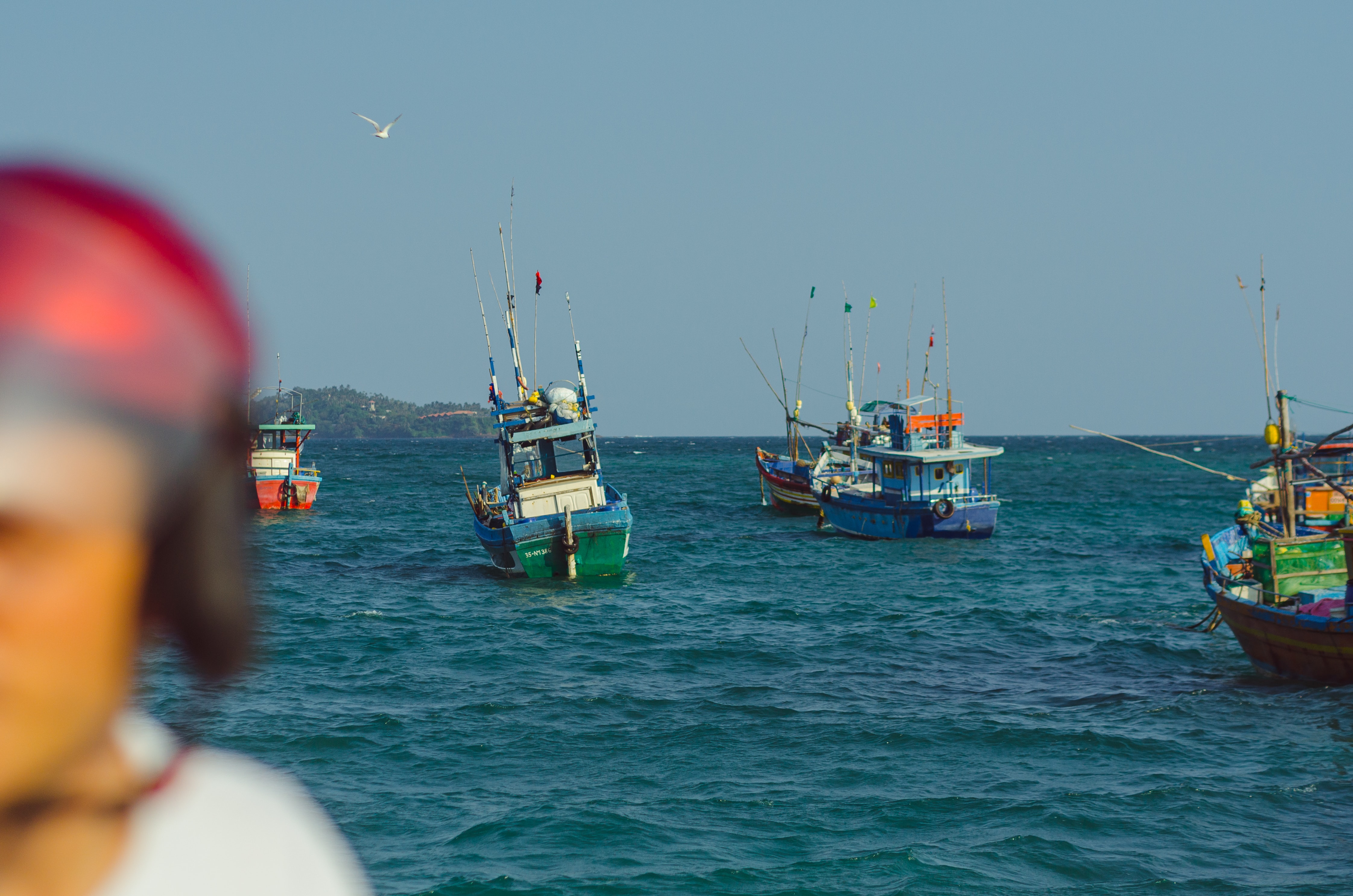 Many colourful fishermen boats out in the blue sea in this Sri Lanka travel guide.