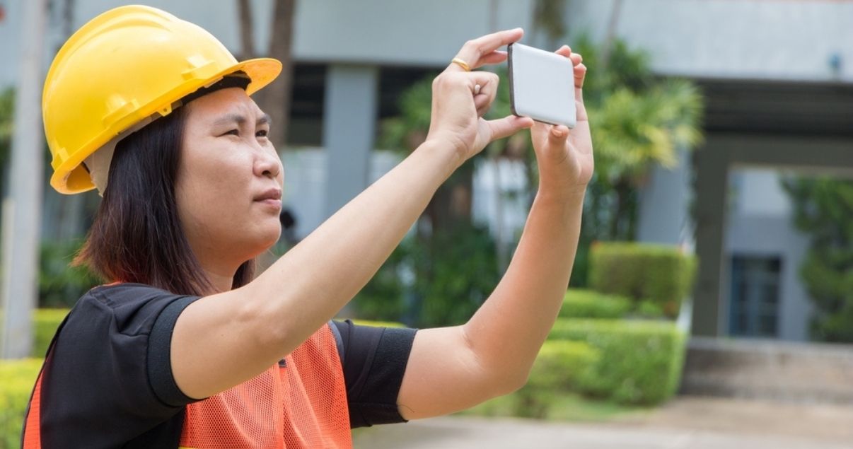 Female inspector taking a picture of an evaluated site